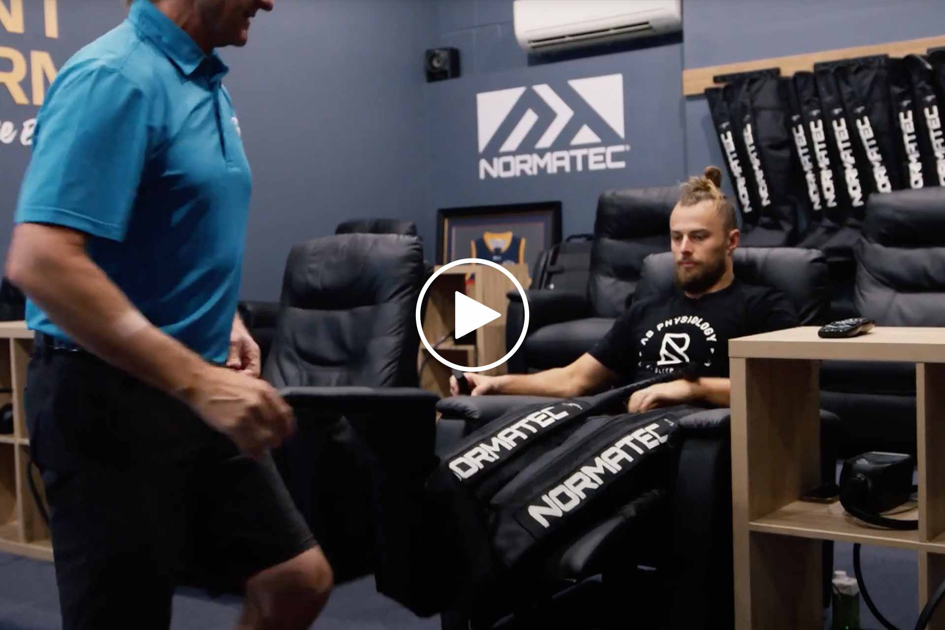 Man helping another man wear P3 recovery normatec Compression Therapy garments